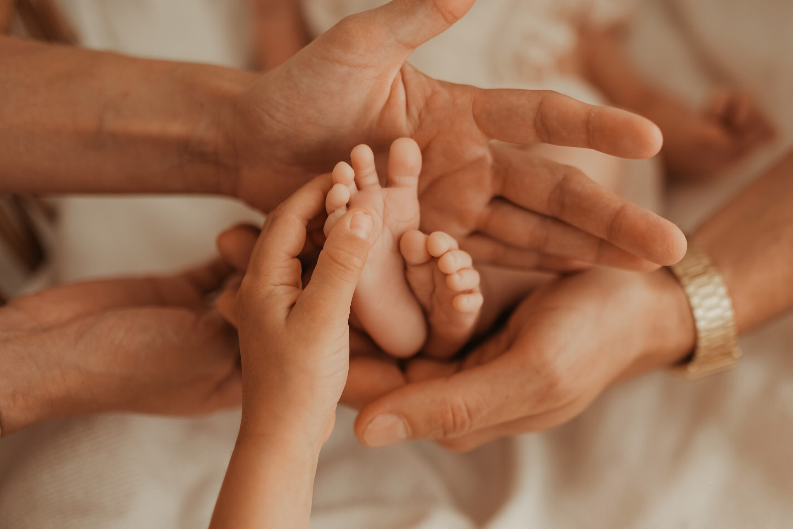 Les petits pieds de bébé dans les mains de toute la famille